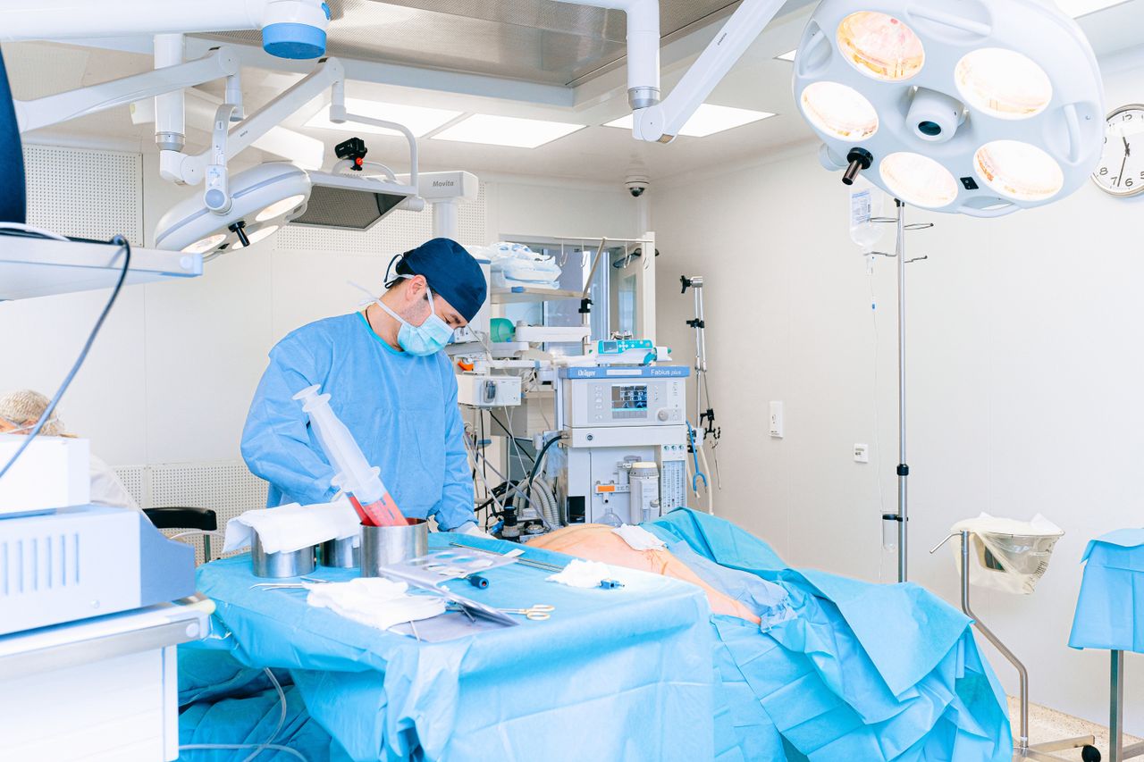 about-us Experienced surgeon performing a procedure in a well-equipped operating room.